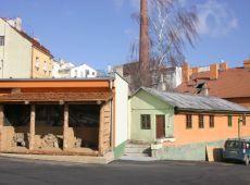 Celkový pohled na Malé muzeum archeologie na dvoře areálu. Vlevo venkovní prezentace časně slovanských pecí.