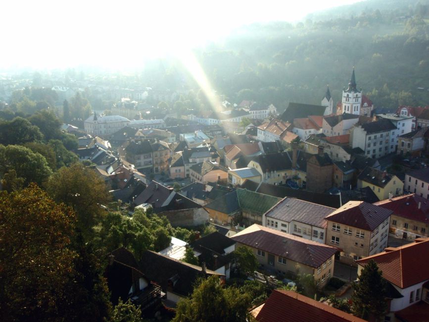 Město Vimperk v pohledu z hradu v dopoledním slunci.