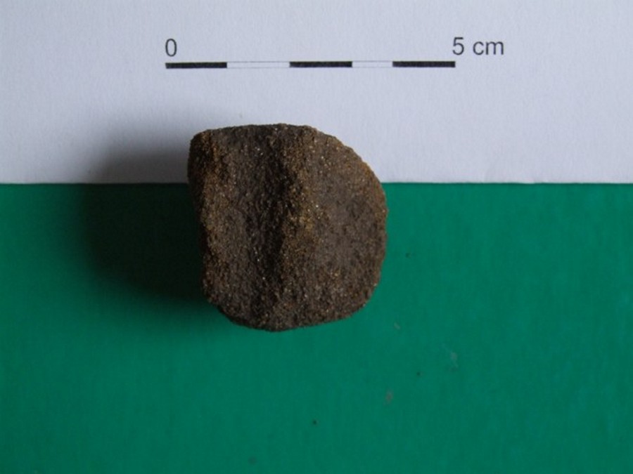 Fragment drobné vrtané kamenné bulavy či přeslenu.